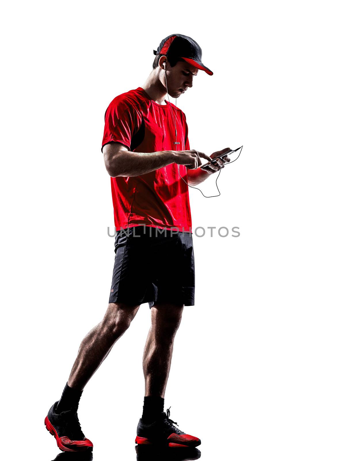 one young man runners joggers using smartphones headphones in silhouettes isolated on white background