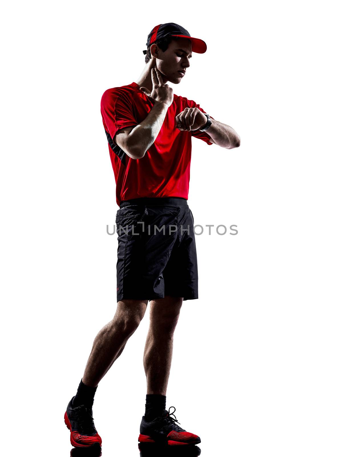 one young man runners joggers taking heartbeat pulse in silhouettes isolated on white background