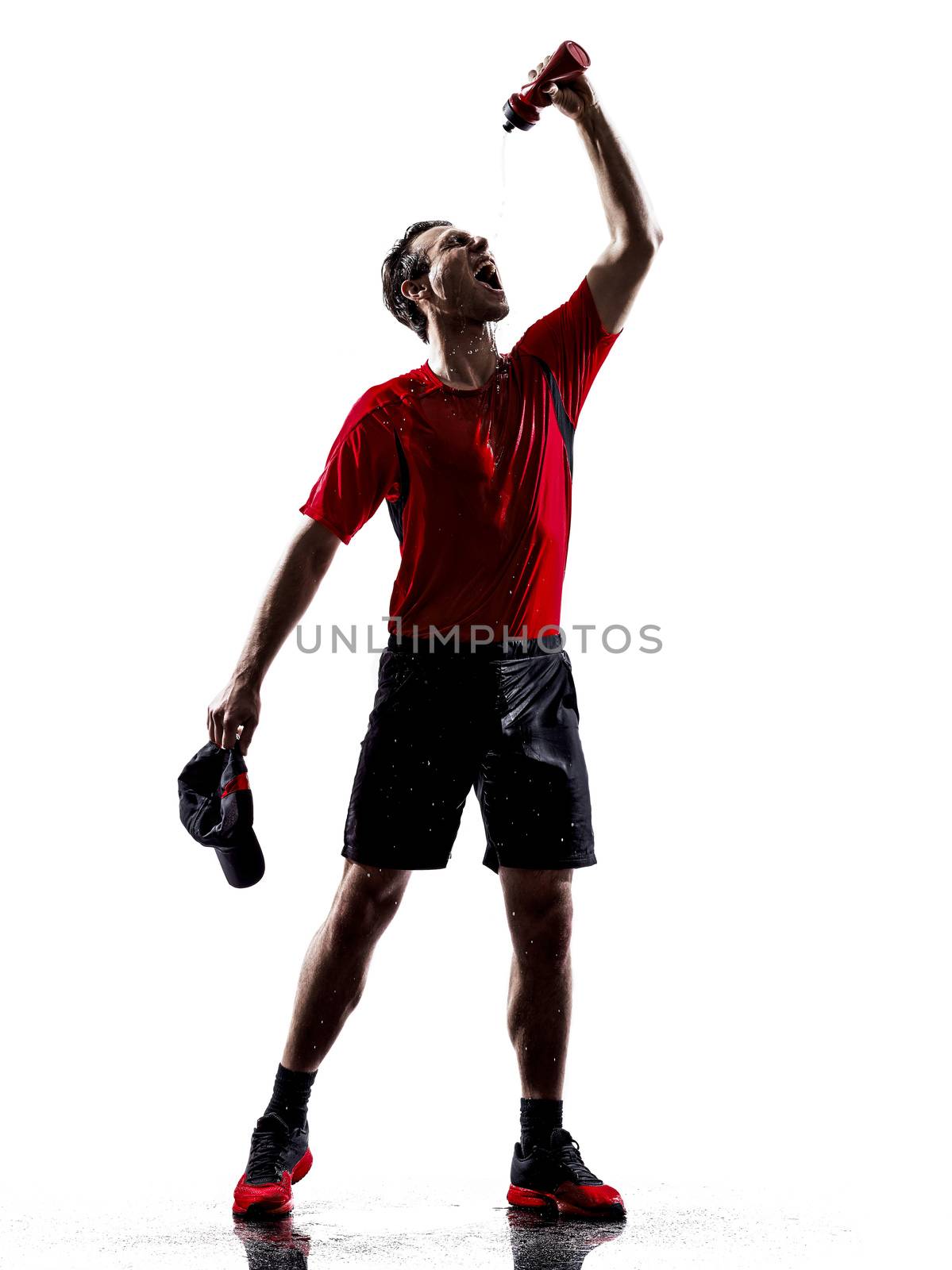 one young man runners athletes drinking energy drinks in silhouettes isolated on white background