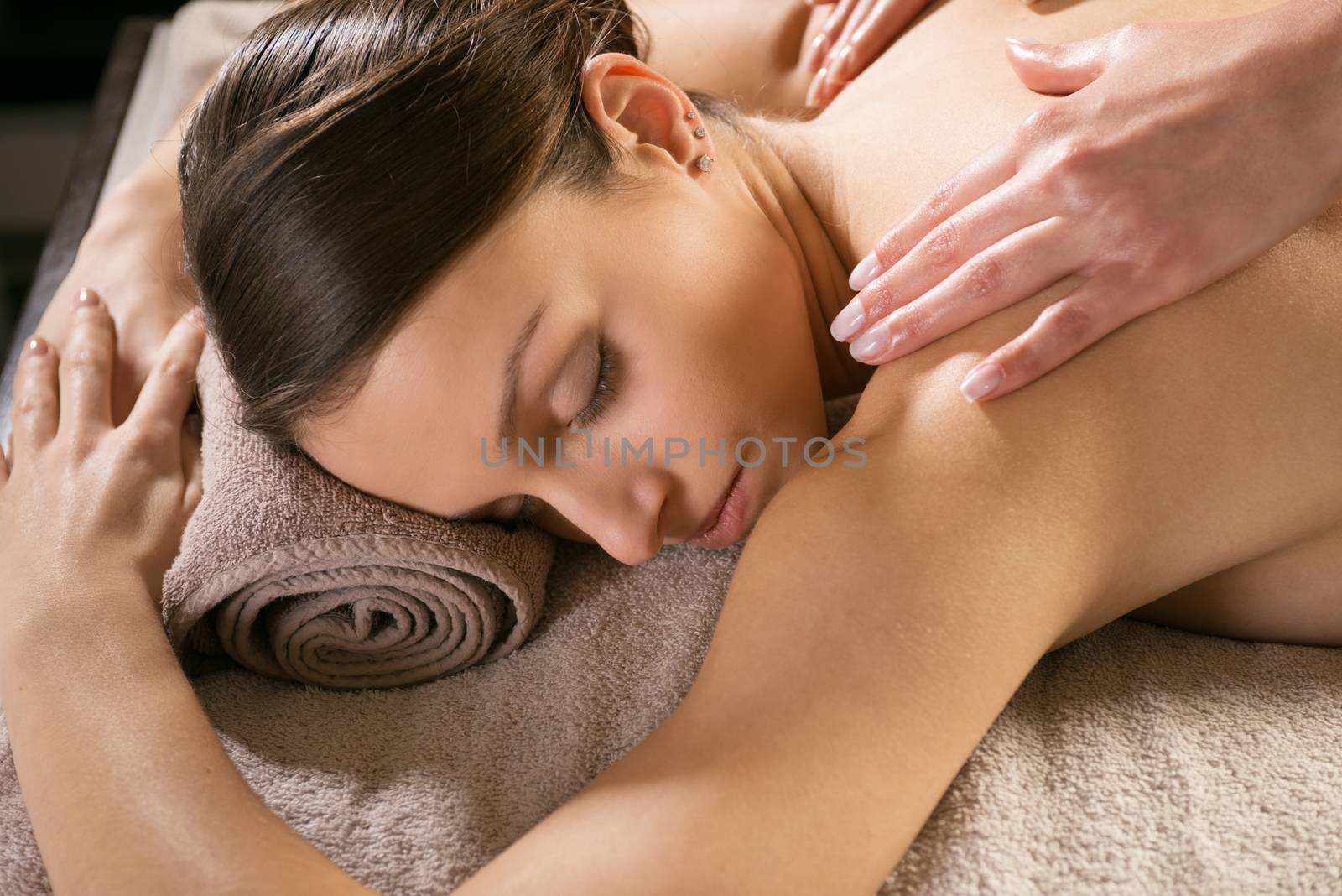 Beautiful woman receiving a relaxing back massage at spa.