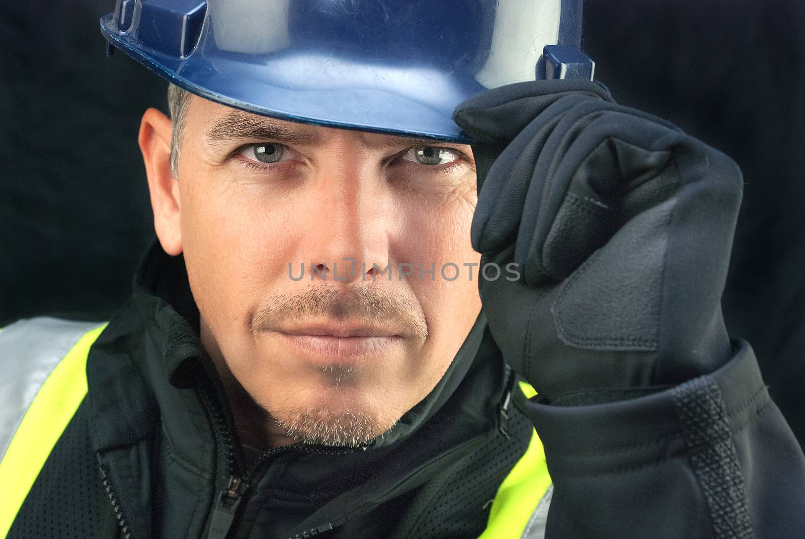 Close-up of a construction worker putting on his hardhat.