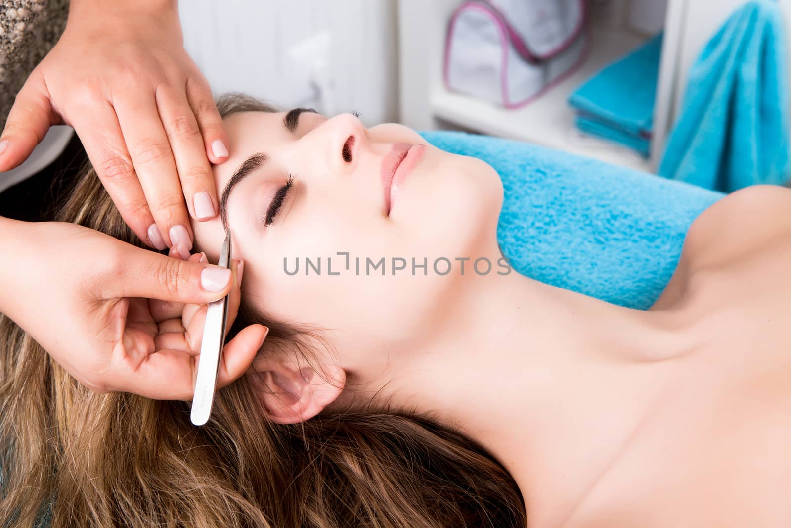 Woman getting tweezing eyebrow by jolopes