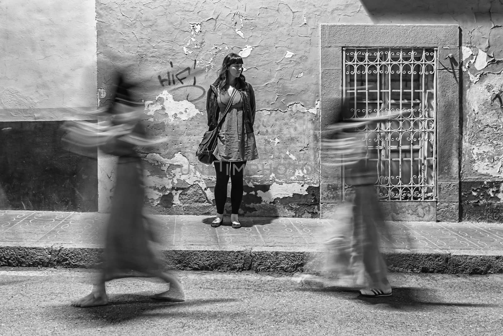 Linares, jaen province, SPAIN - March 16, 2014: Girl still watching how they spend nazarenos carrying a cross at full speed during Holy Week in Linares, Jaen province, Andalucia, Spain