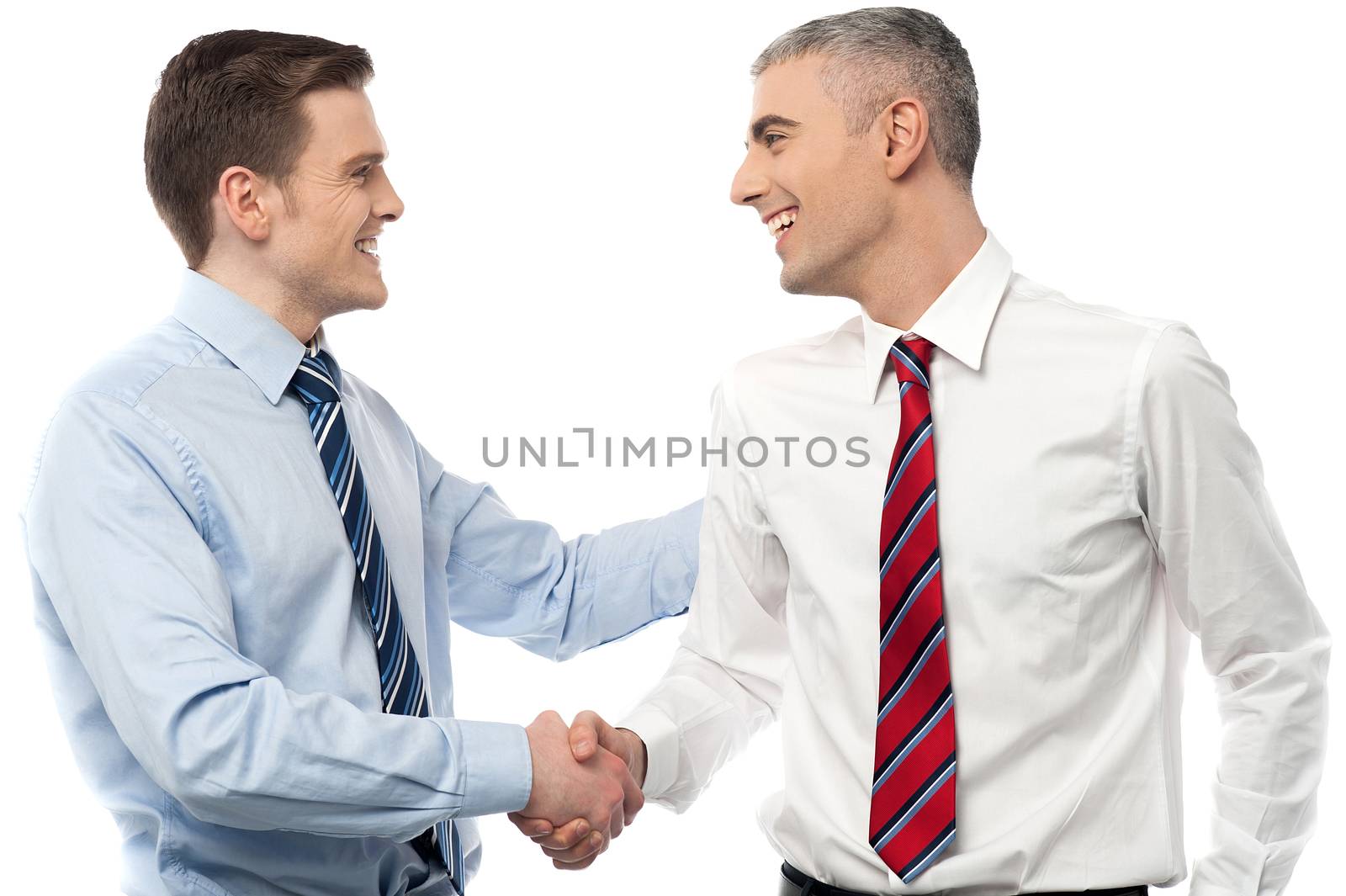 Smiling businessmen shaking hands by stockyimages