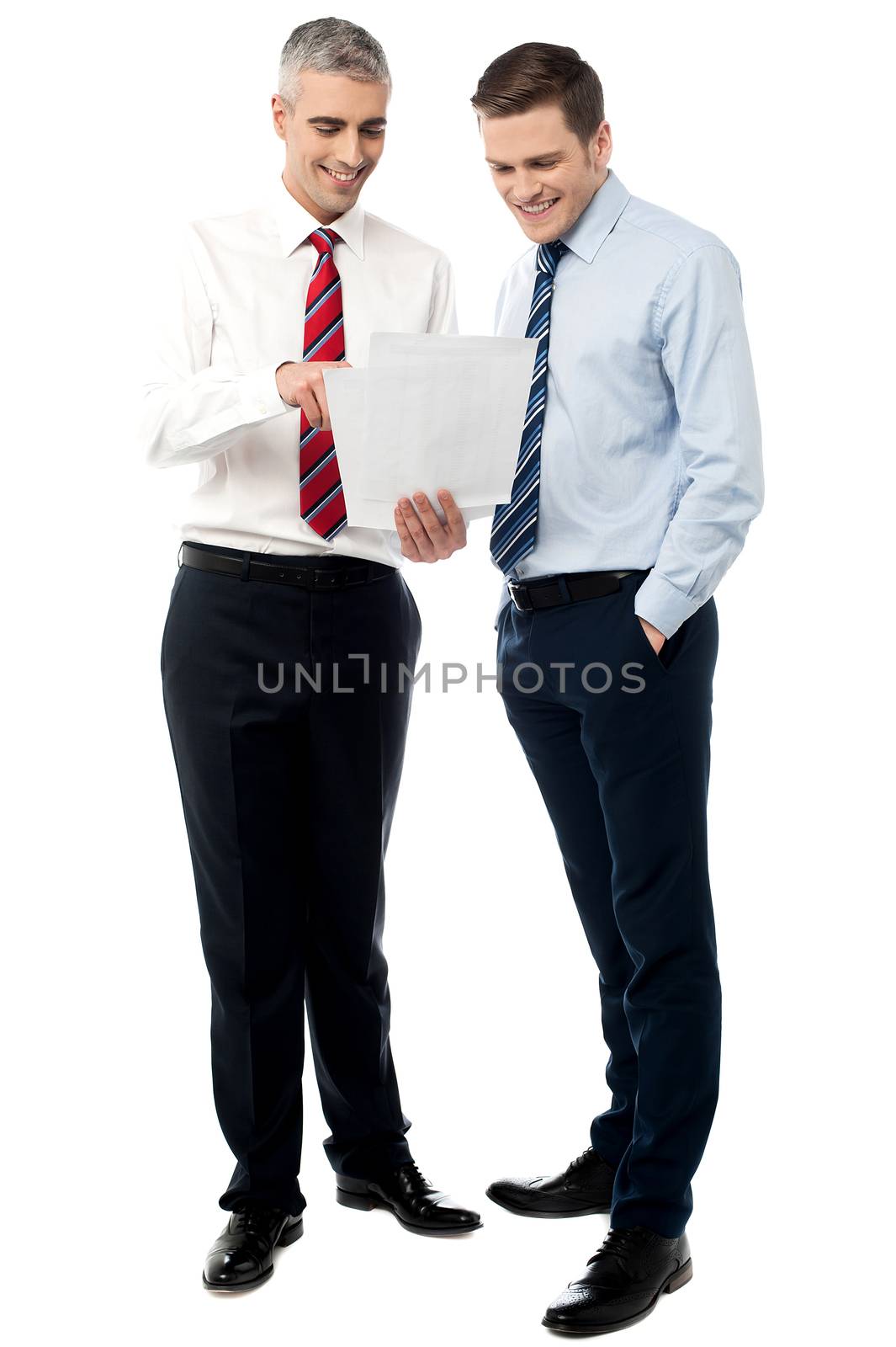 Young executives discussing business reports by stockyimages
