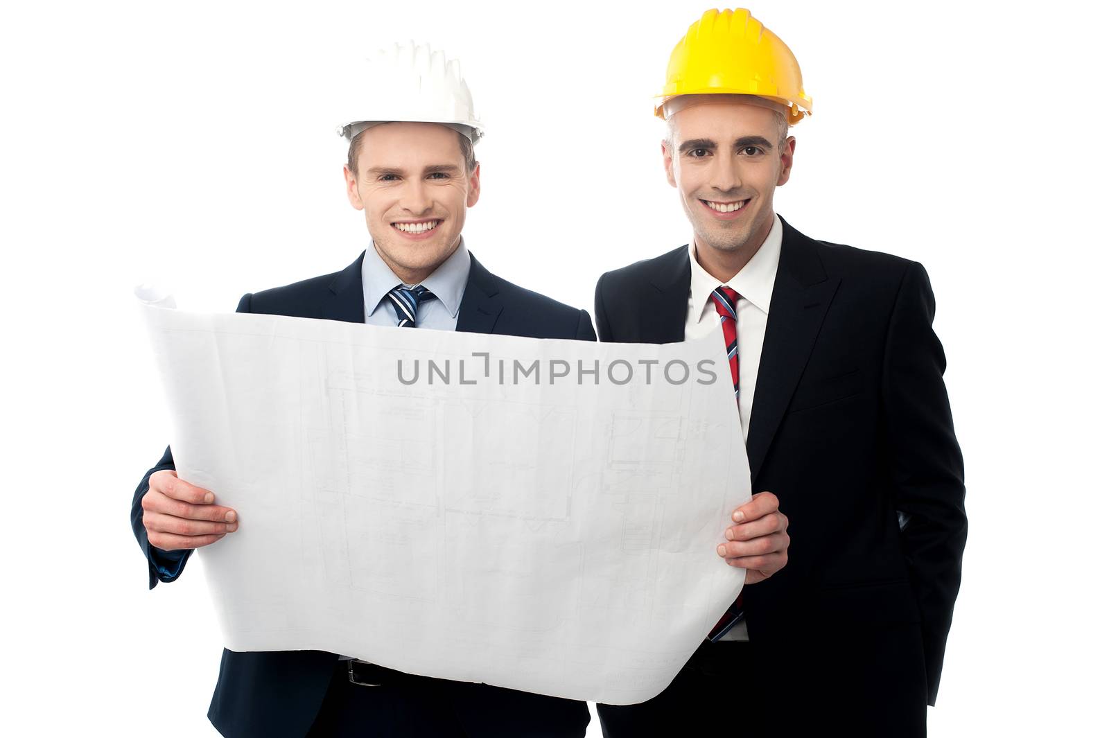 Smiling engineers in hard hats with blueprints
