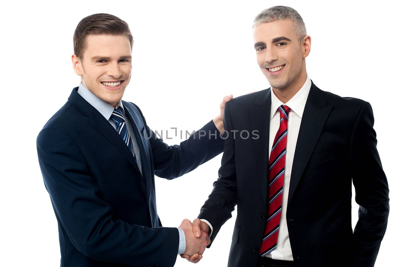 Successful businessmen shaking hands by stockyimages