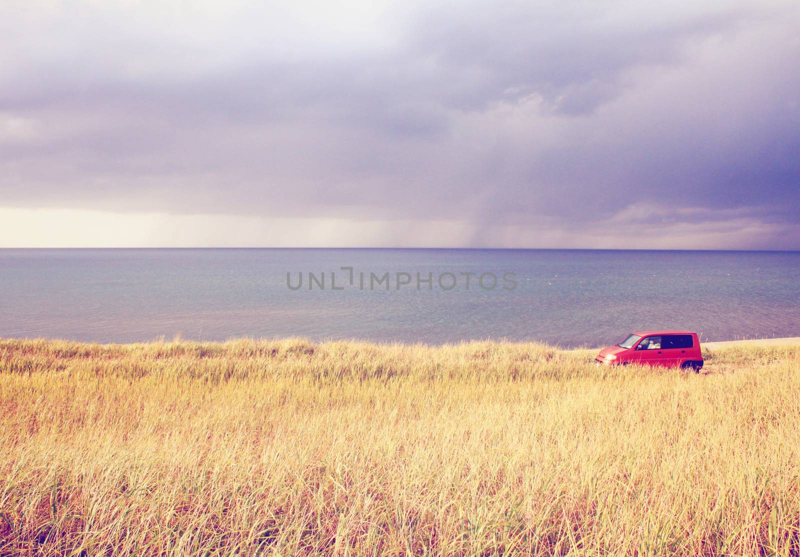 Red car parking in the field with retro filter effect 