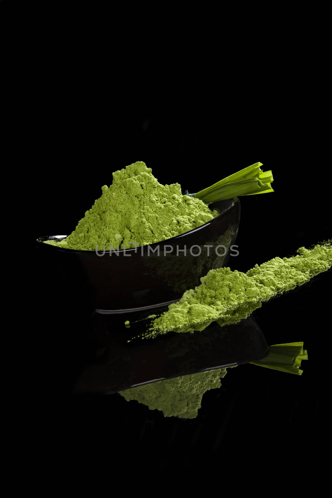 Spirulina, chlorella and wheatgrass ground and grass blades isolated on black background. Healthy living, alternative medicine. 