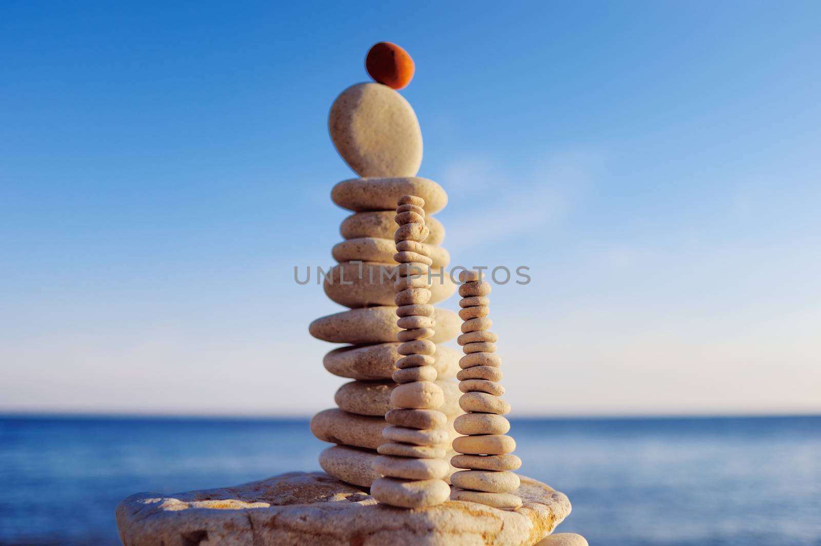 Balance of red stone on the top of stack of white pebbles