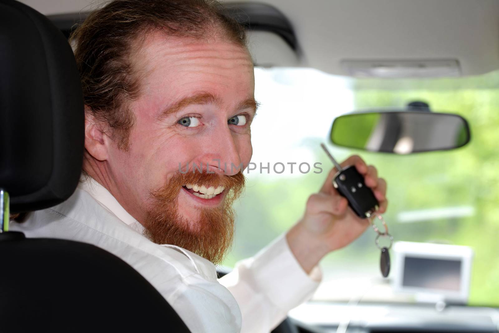 driver smiling sitting in car and showing new car keys  by vladacanon