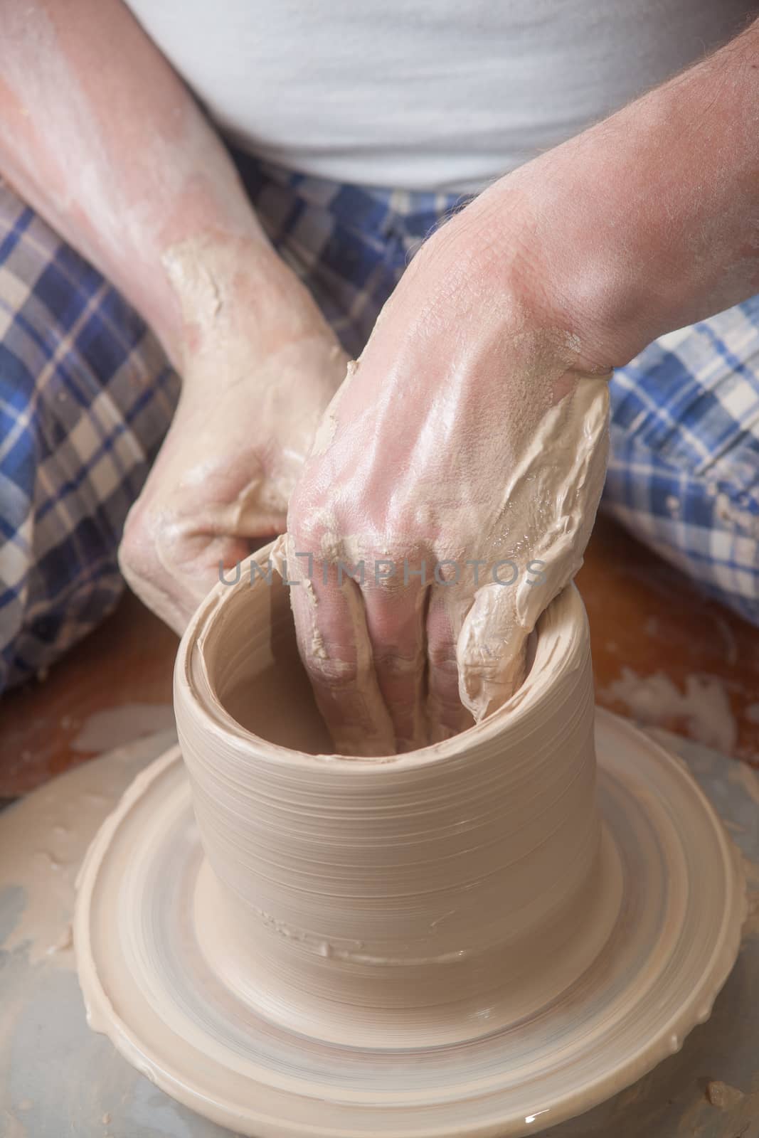 Hands of a potter, creating an earthen jar on the circle