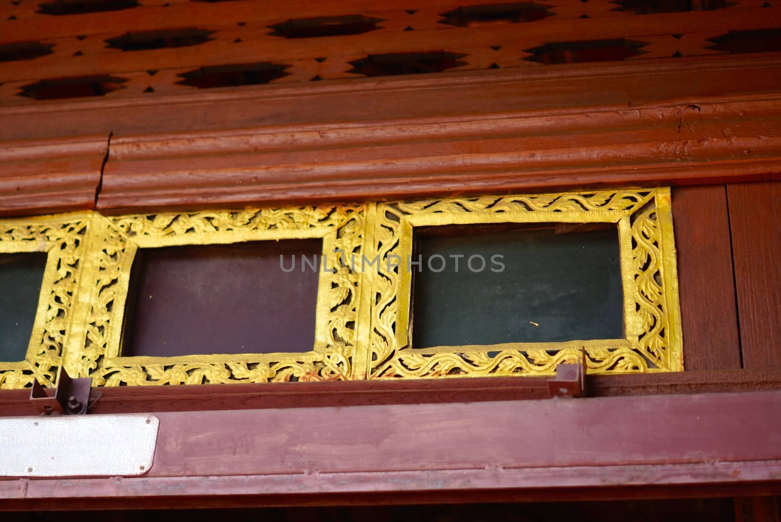 the detail of ancient thai pattern is showing handmade wood carving worked and decorated with gold plate,mirror and precious stone,Lampang temple ,Thailand