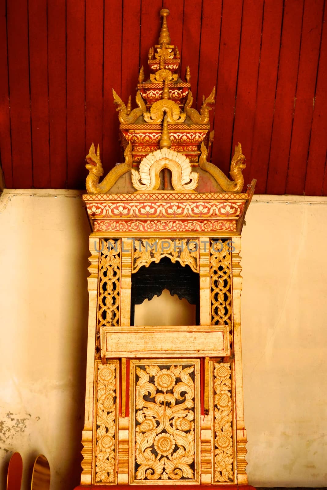 the detail of ancient thai decorated pattern that include handcraft wood carving work,gold painting and decorated with gold plate,mirror and precious stone,Lampang temple,Thailand