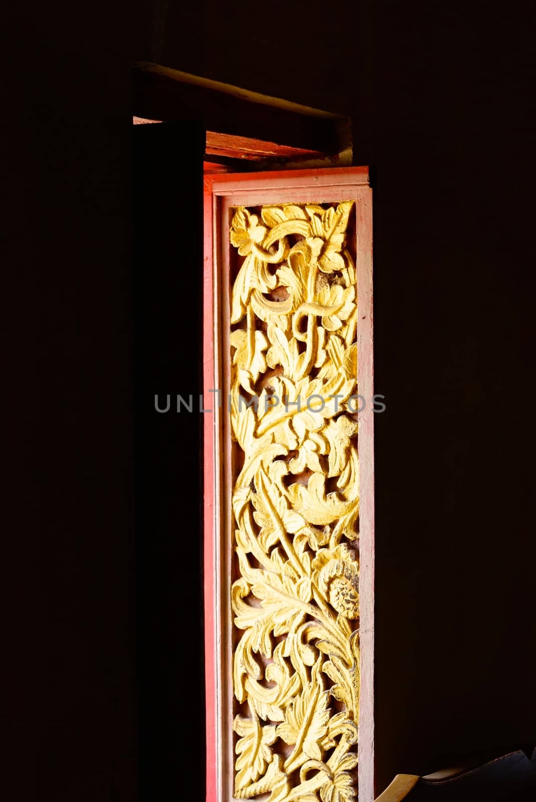 the detail of ancient thai decorated pattern that include handcraft wood carving work,gold painting and decorated with gold plate,mirror and precious stone,Lampang temple,Thailand