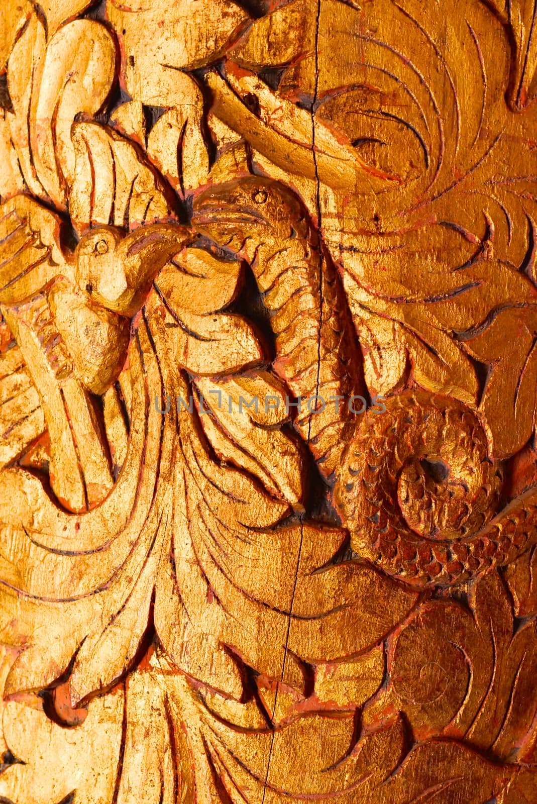 the detail of ancient thai decorated pattern that include handcraft wood carving work,gold painting and decorated with gold plate,mirror and precious stone,Lampang temple,Thailand