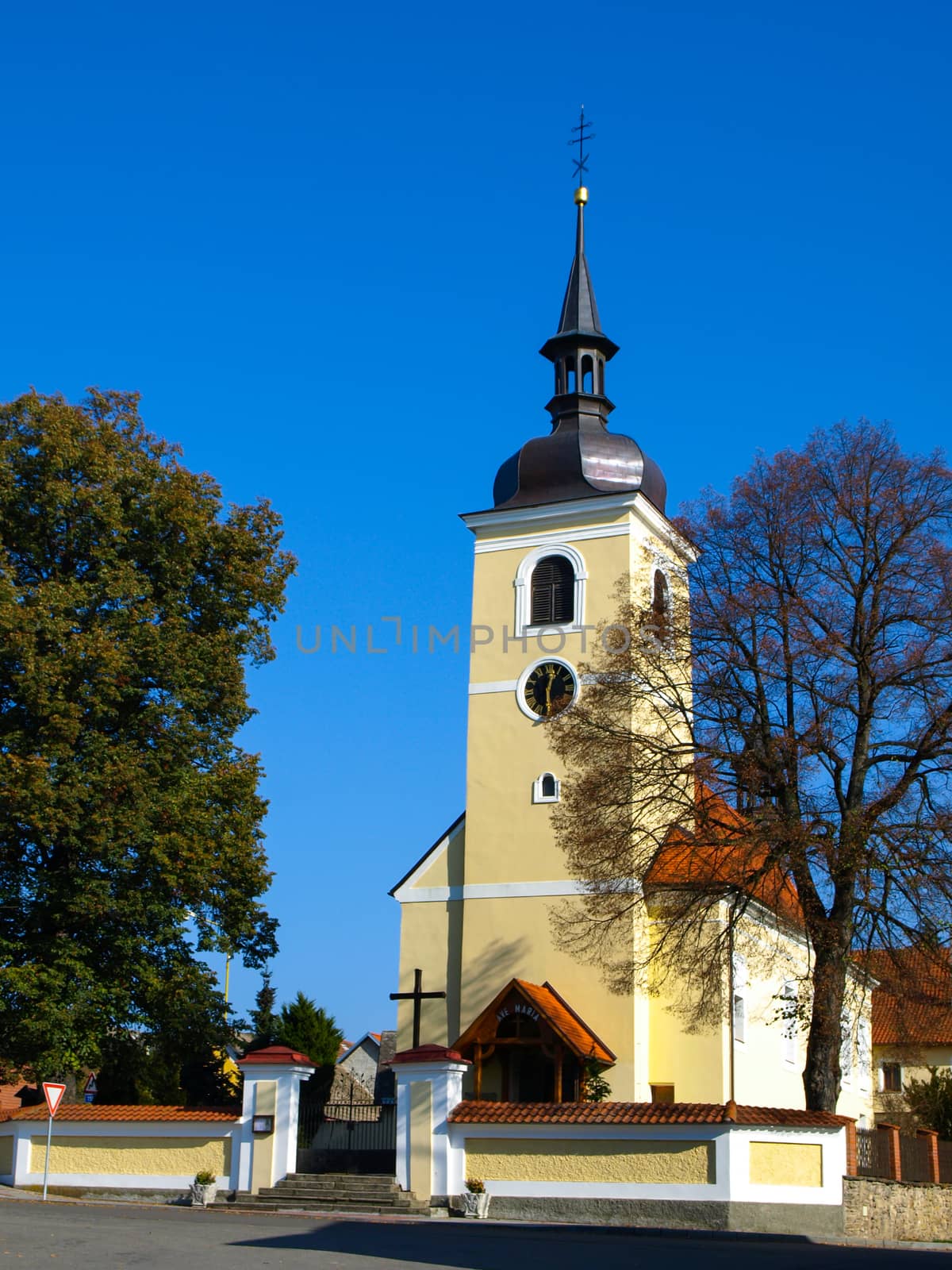 Small yellow village church by pyty