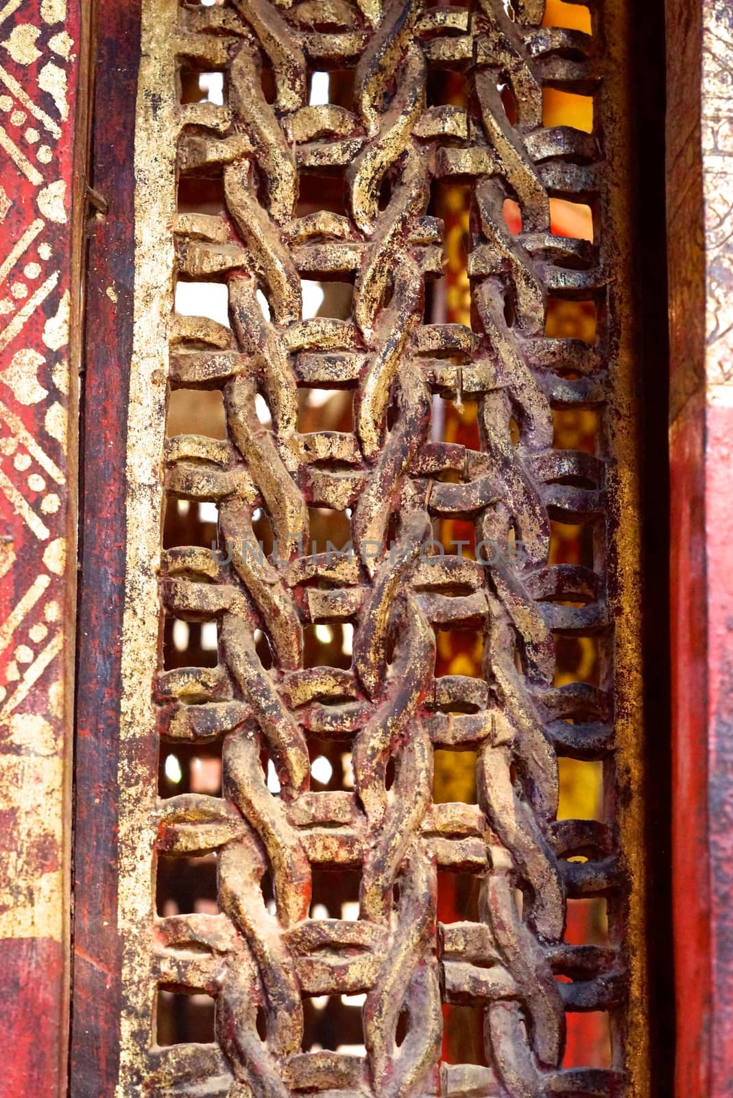 the detail of ancient thai decorated pattern that include handcraft wood carving work,gold painting and decorated with gold plate,mirror and precious stone,Lampang temple,Thailand
