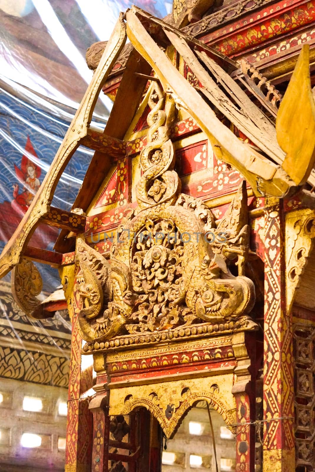 the detail of ancient thai decorated pattern that include handcraft wood carving work,gold painting and decorated with gold plate,mirror and precious stone,Lampang temple,Thailand
