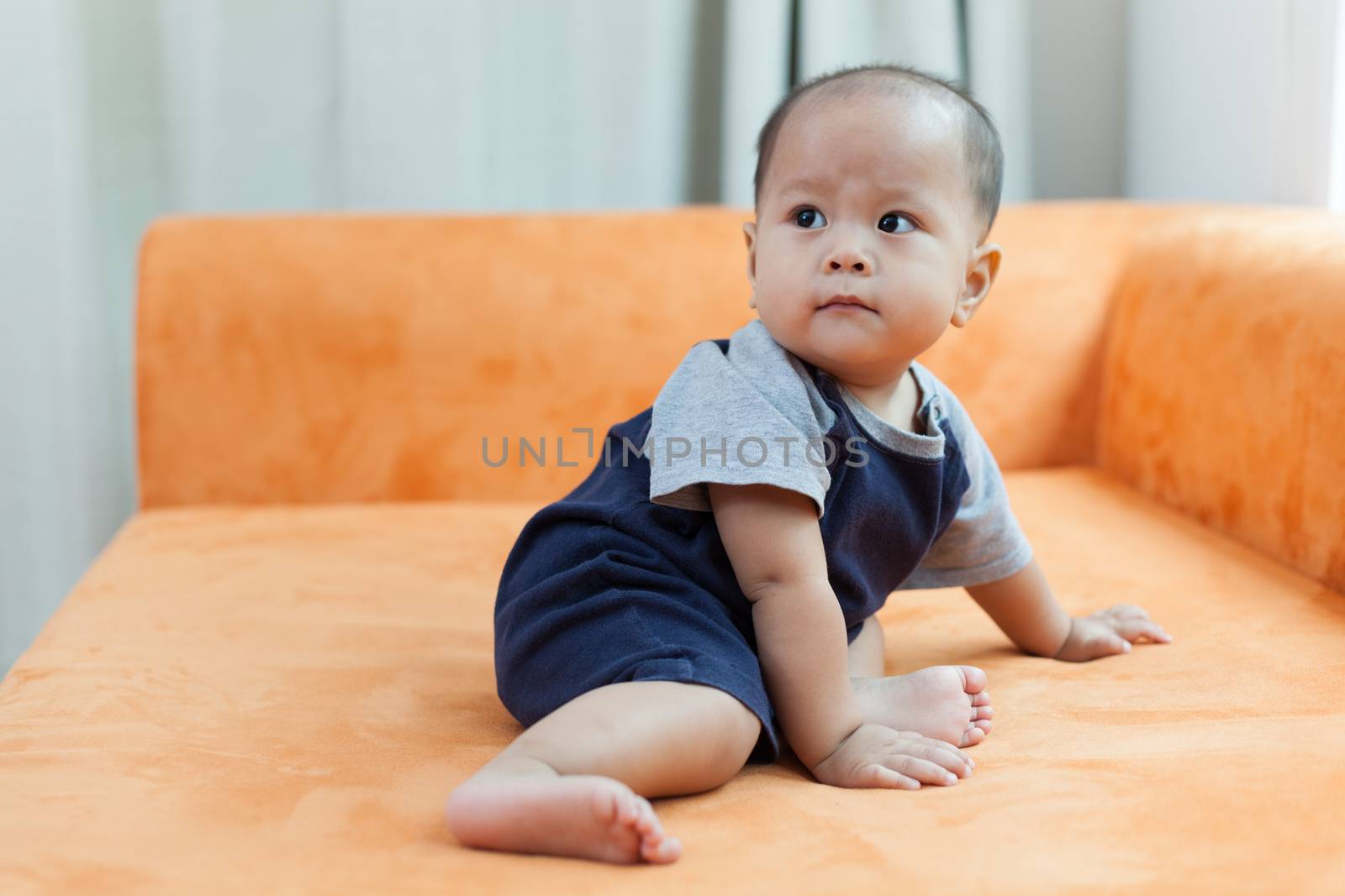 Baby boy.child Asian., And played on the orange sofa.