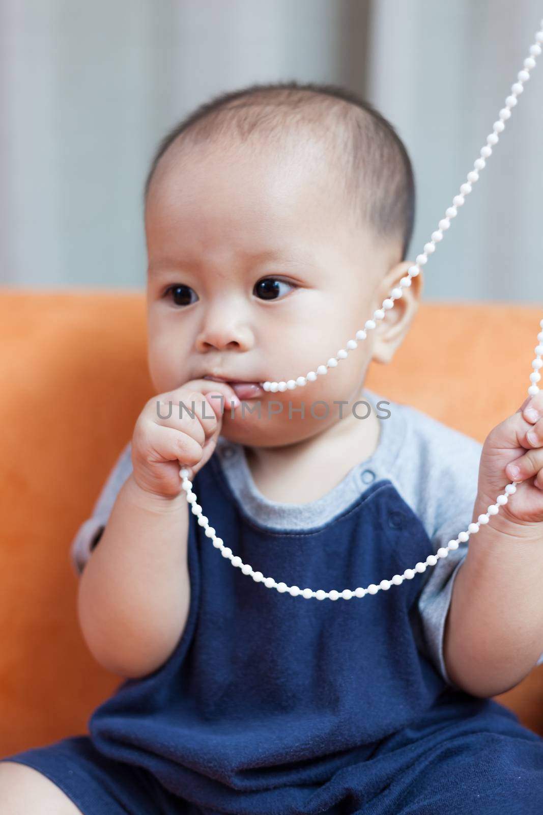 Baby boy.child Asian., And played on the orange sofa.