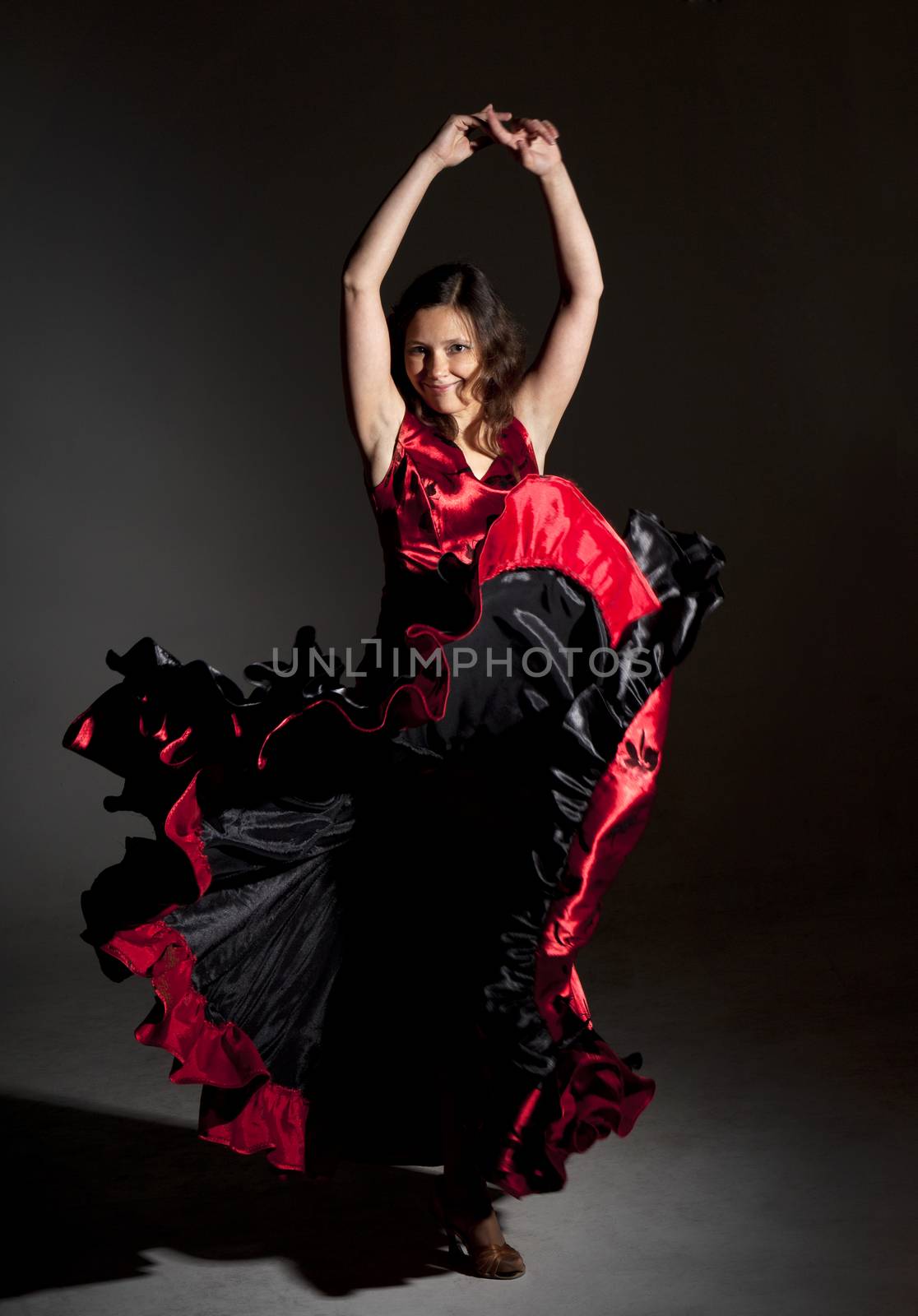 Young woman dancing flamenco, studio shot, gray background