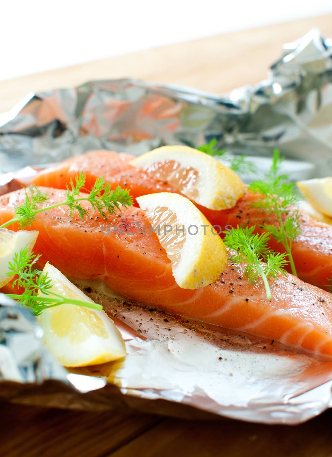 Fresh salmon fillets with lemon wedges and dill