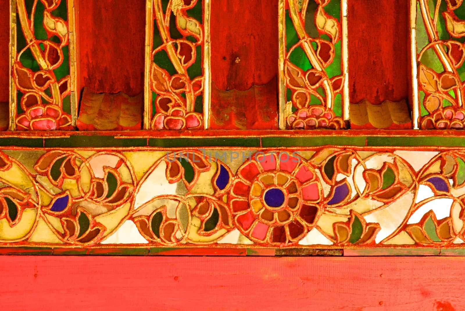 the detail of ancient thai decorated pattern that include handcraft wood carving work,gold painting and decorated with gold plate,mirror and precious stone,Lampang temple,Thailand