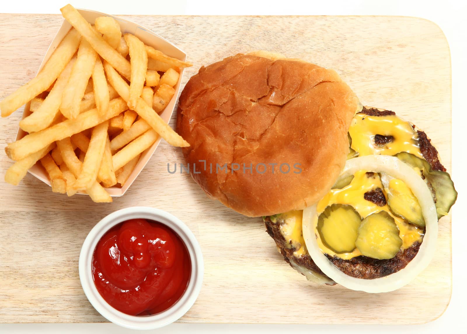 Top View Burger and Fries Served on Cutting Board with Ketchup.