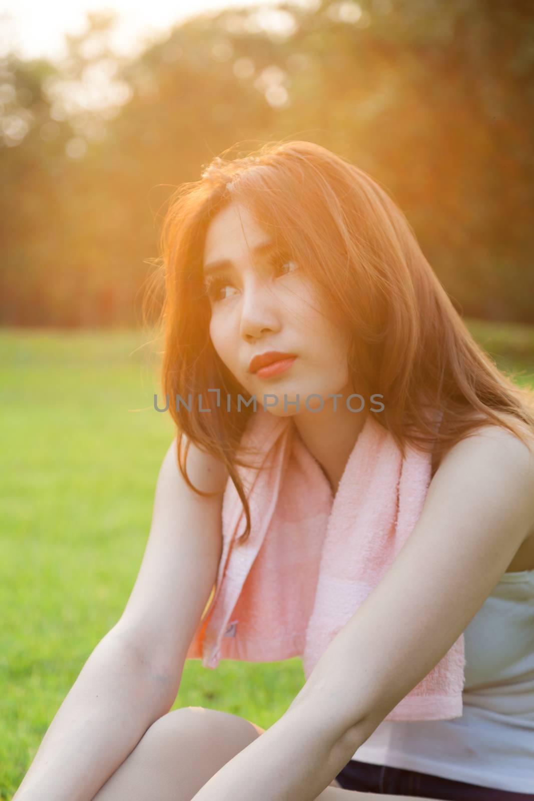 Woman sitting on lawn in park. by a454