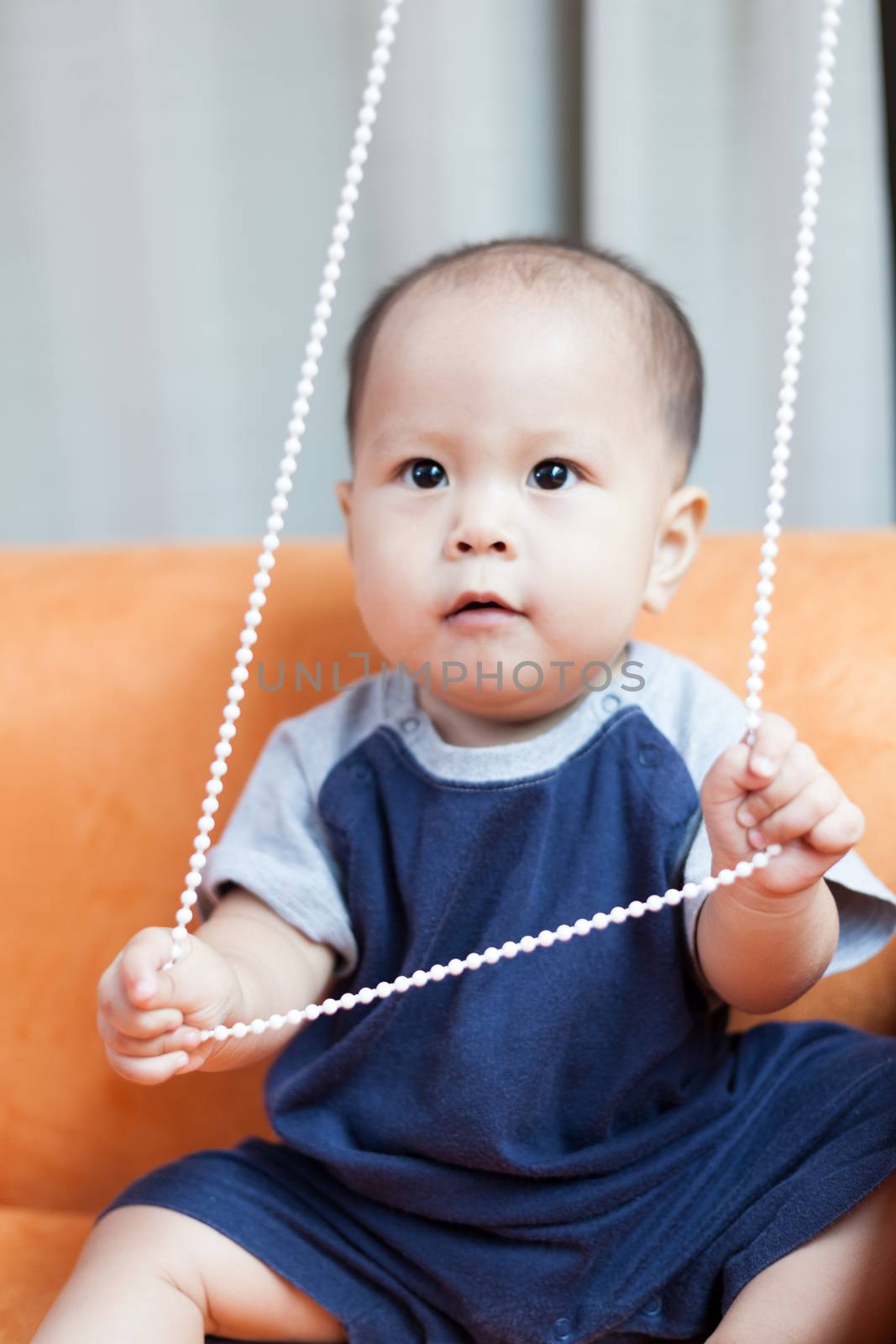 Baby boy.child Asian., And played on the orange sofa.