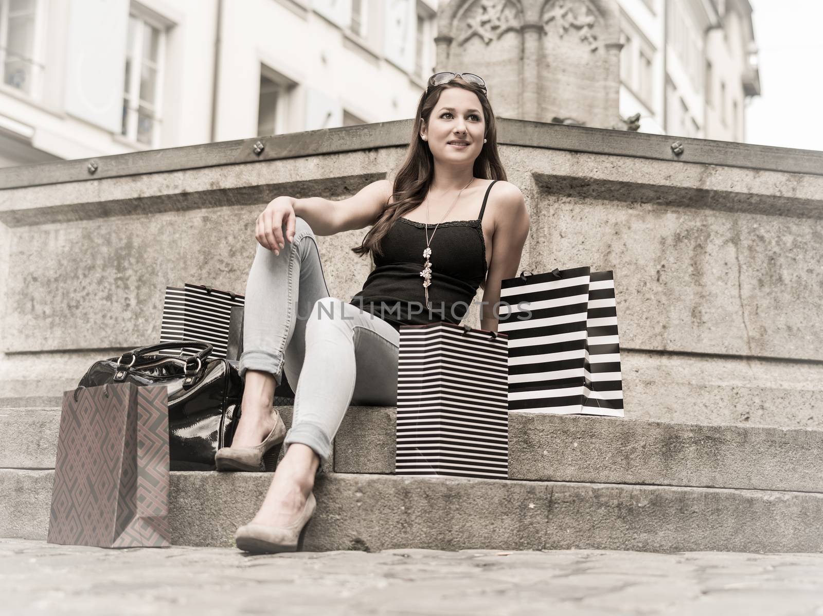 Young woman in the city with shopping bags by sumners
