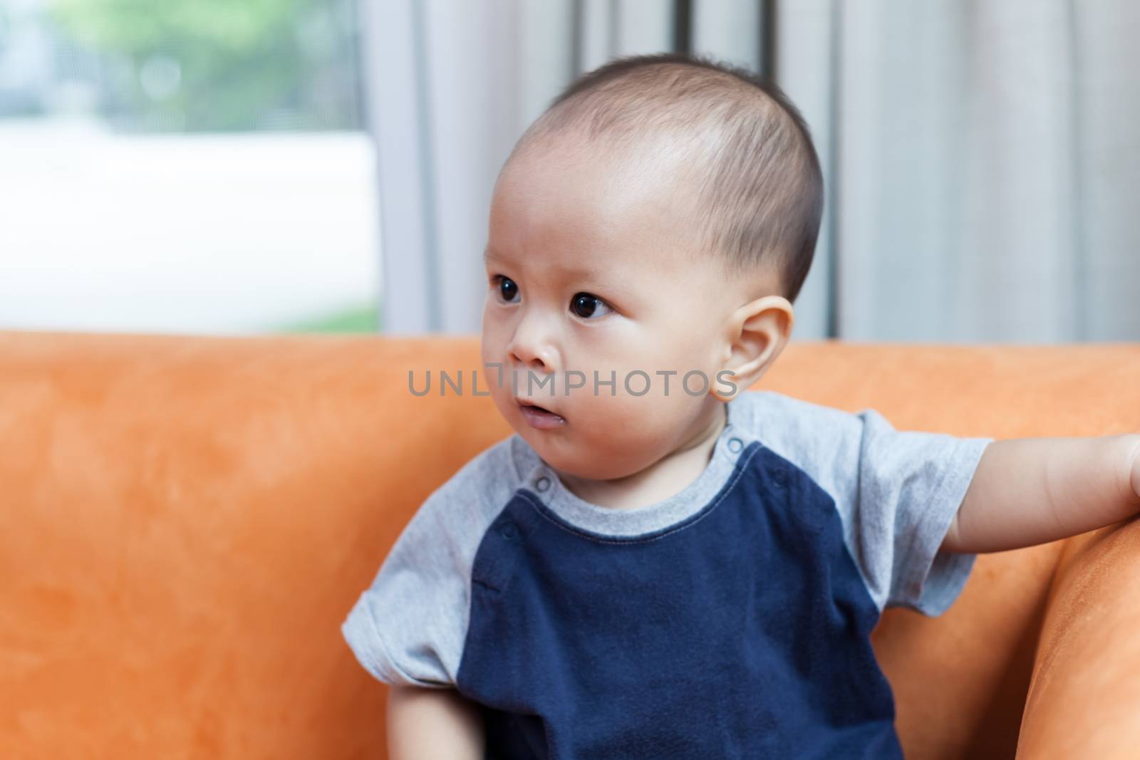 Baby boy.child Asian., And played on the orange sofa.