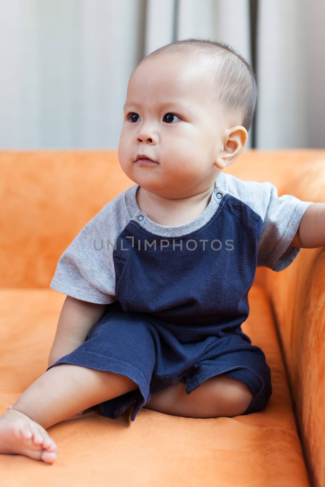 Baby boy.child Asian., And played on the orange sofa.