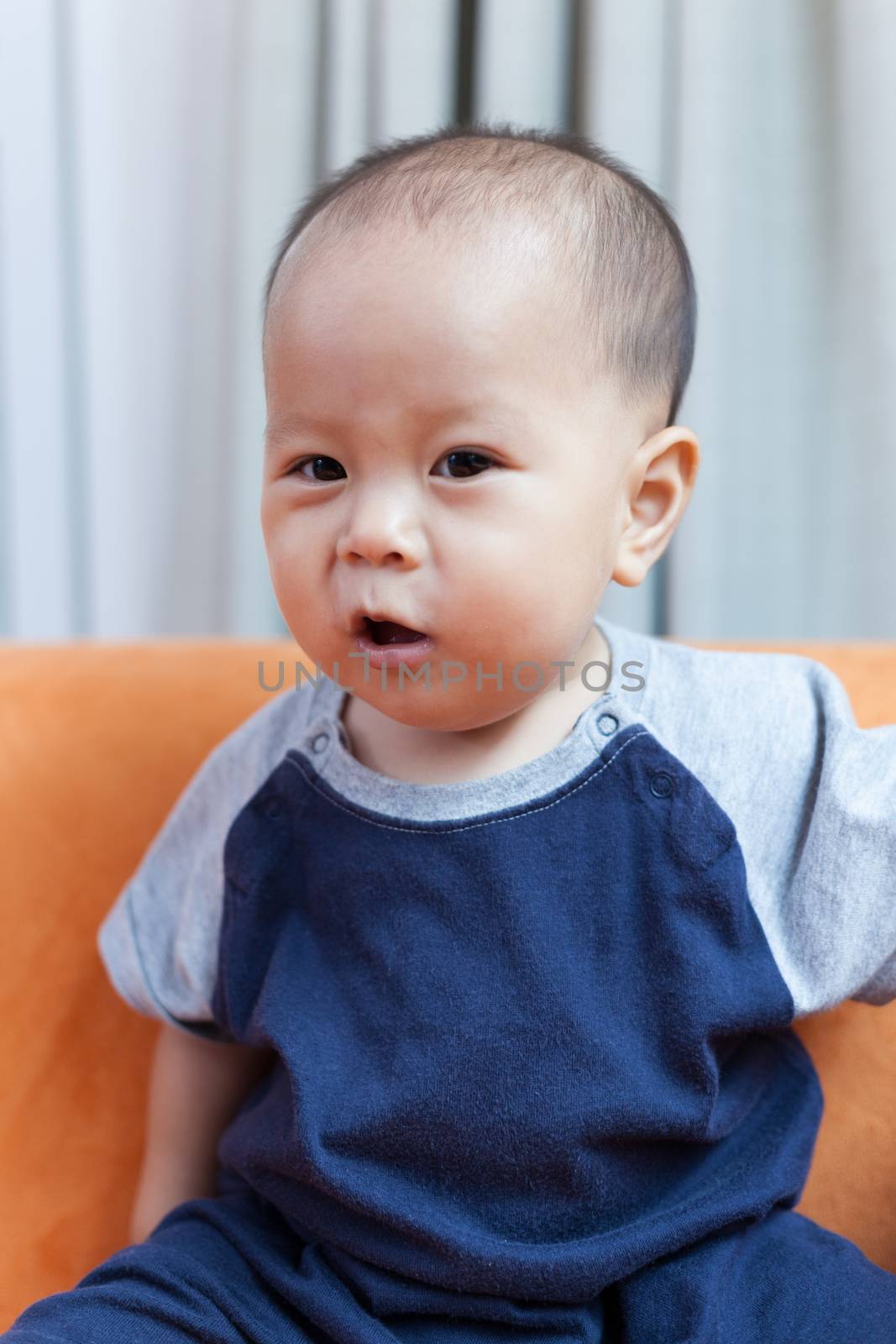 Baby boy.child Asian., And played on the orange sofa.