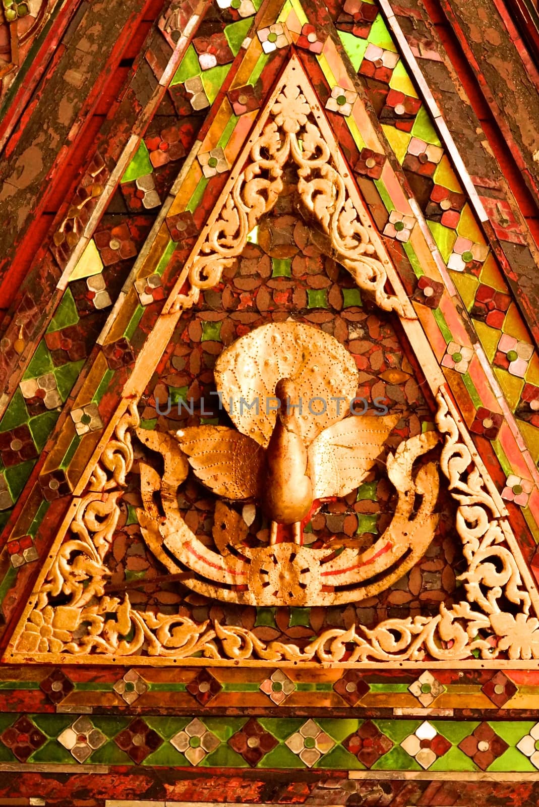 the detail of ancient thai decorated pattern that include handcraft wood carving work,gold painting and decorated with gold plate,mirror and precious stone,Lampang temple,Thailand