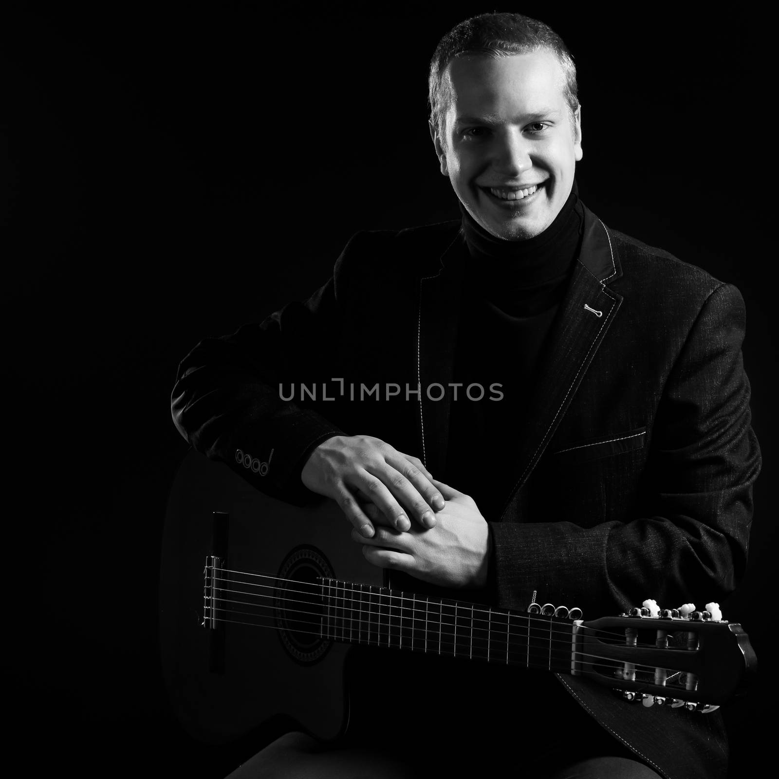 Music. Musician in black suit with a guitar