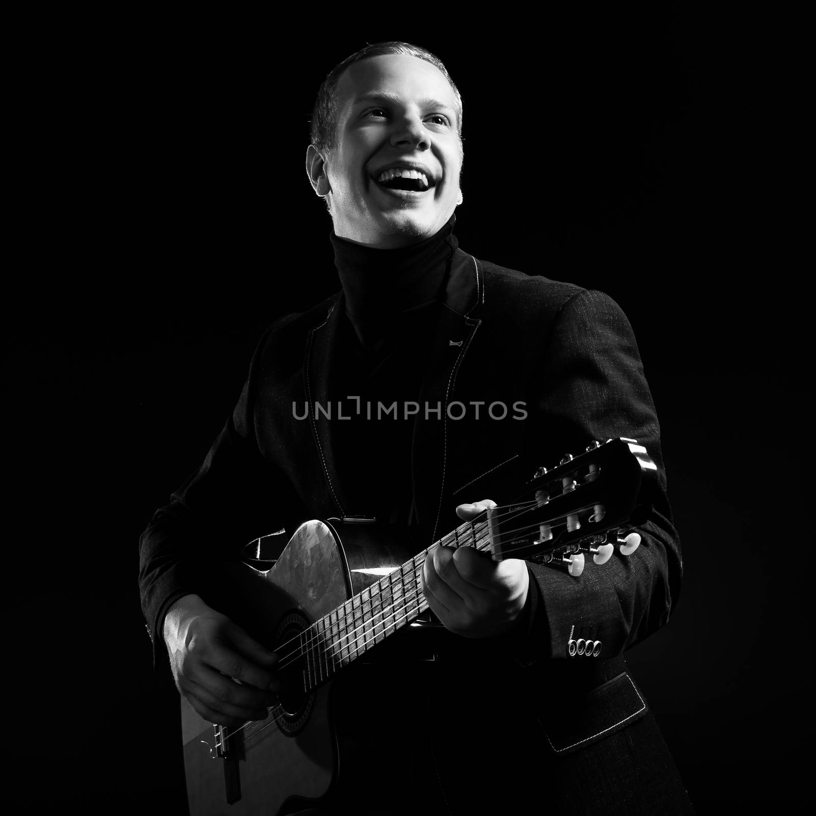 Music. Musician in black suit with a guitar