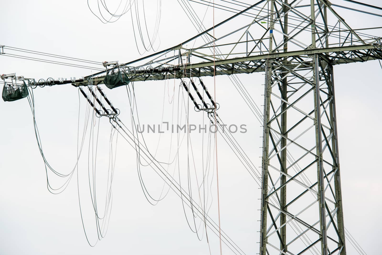 high voltage power pole construction works - cables being mounted