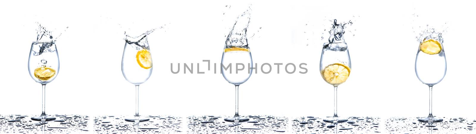 Lemon splashing into glasses full of water on white background