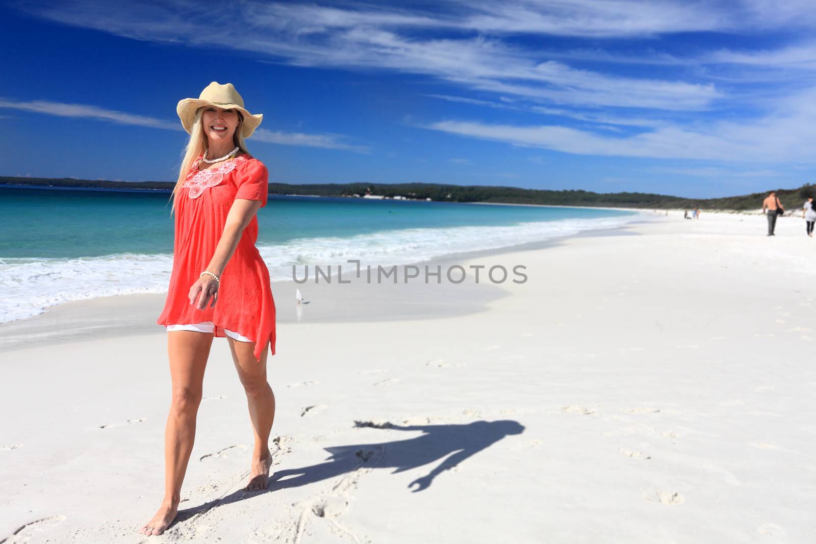 Happy woman walking along beautiful beach by lovleah