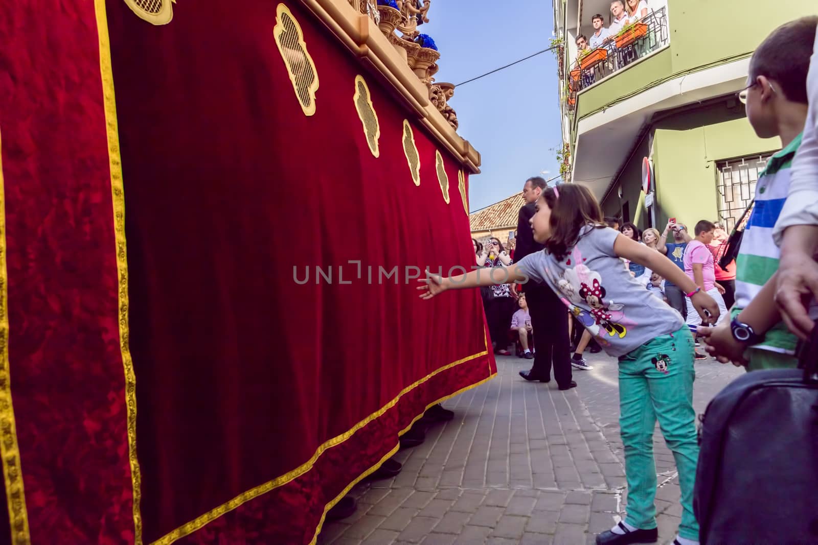 Girl tries to touch the skirt of the throne to have good luck, p by digicomphoto