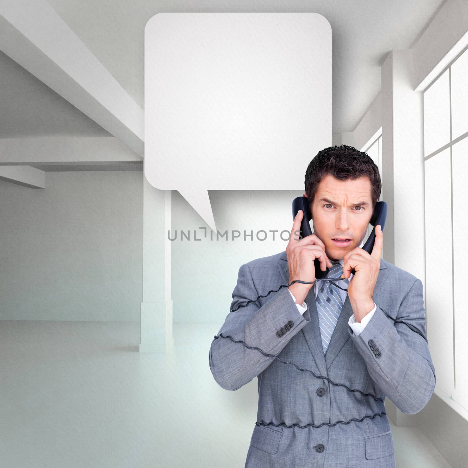 Composite image of angry businessman tangle up in phone wires  by Wavebreakmedia