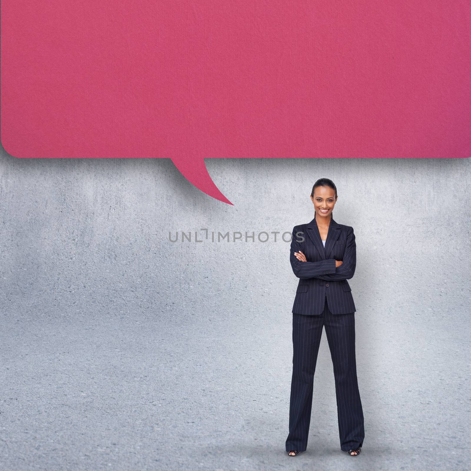 Confident businesswoman with speech bubble against grey wall