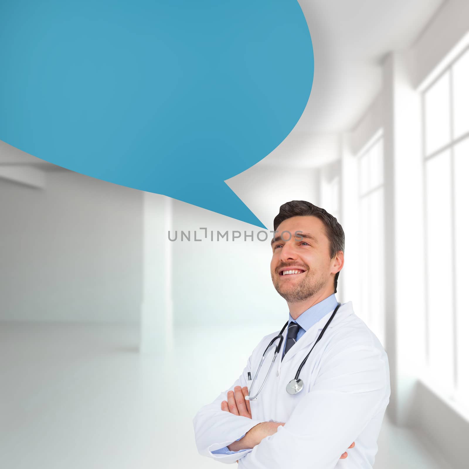 Handsome young doctor with arms crossed with speech bubble against white room with windows