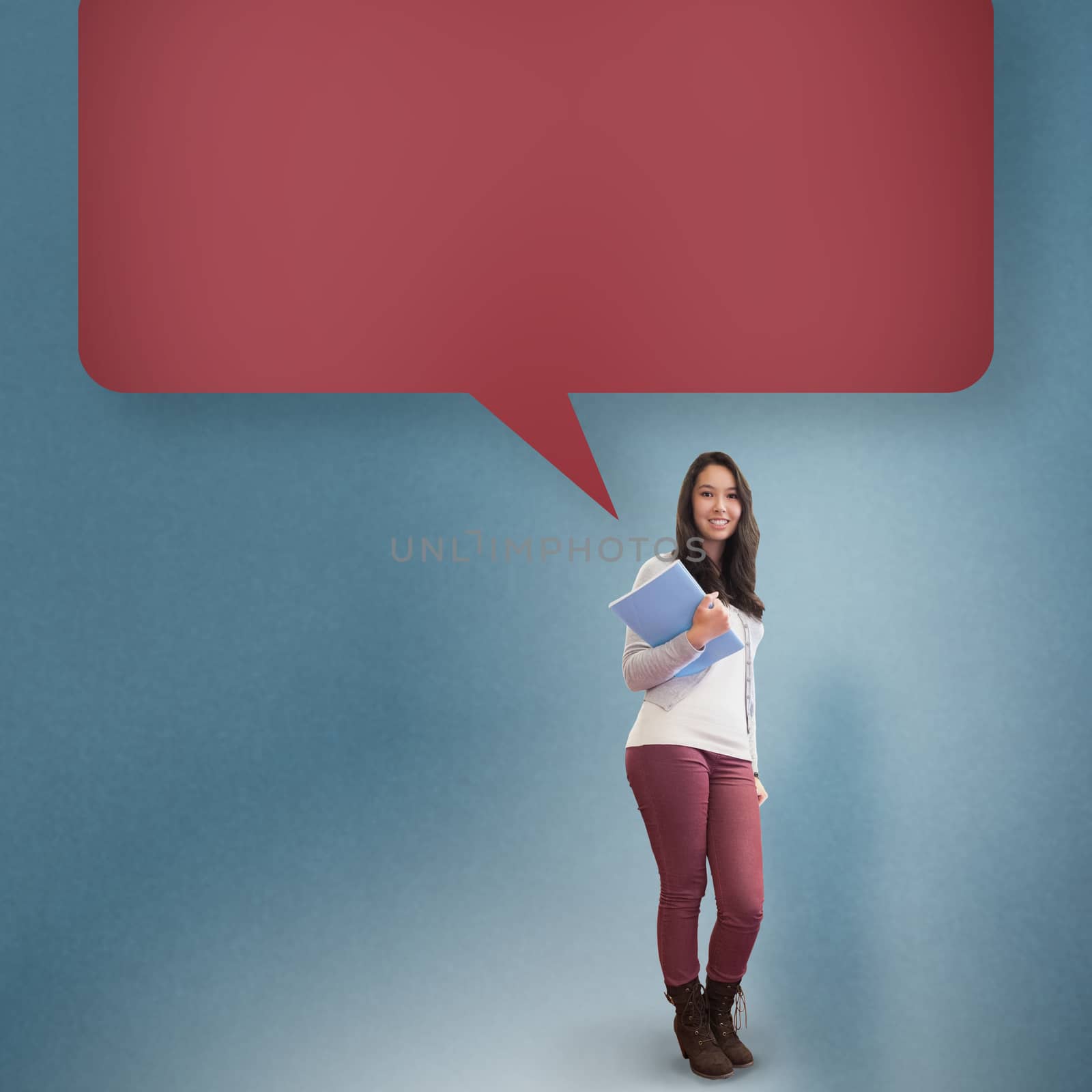 Smiling student holding textbook with speech bubble against blue background with vignette