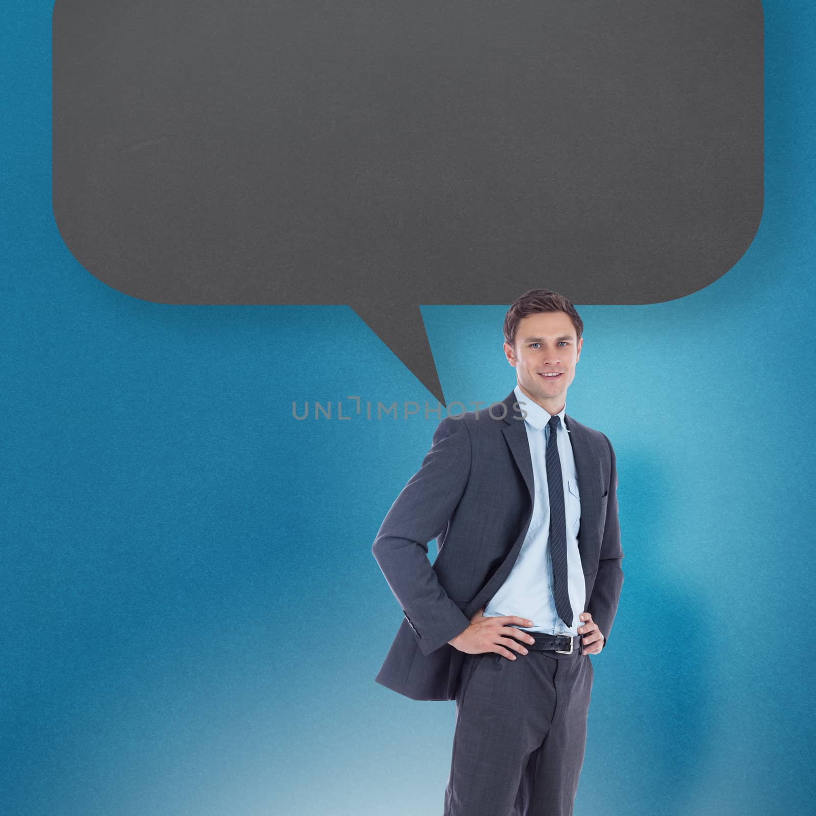 Composite image of smiling businessman with hands on hips with speech bubble by Wavebreakmedia