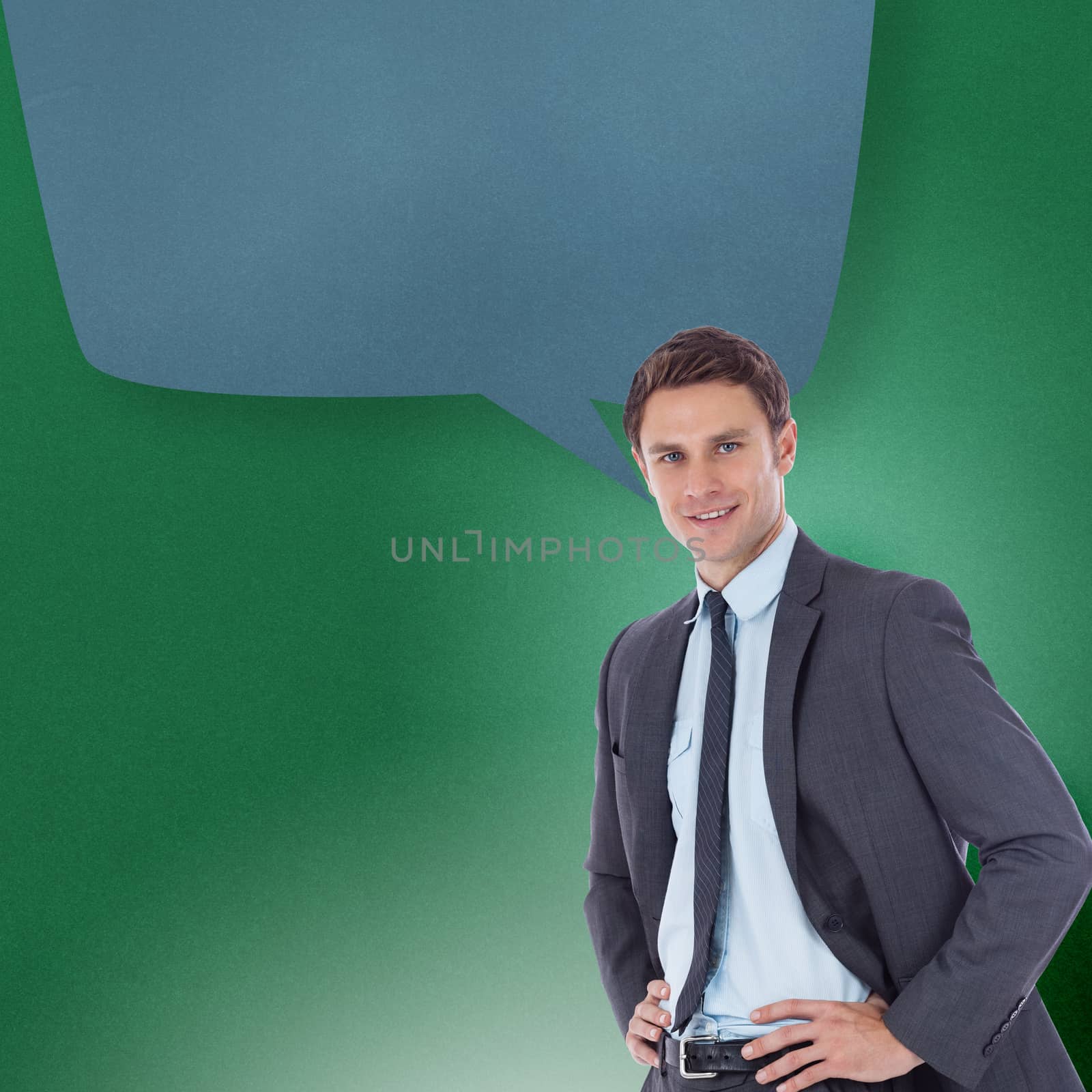 Smiling businessman with hands on hips with speech bubble against green vignette