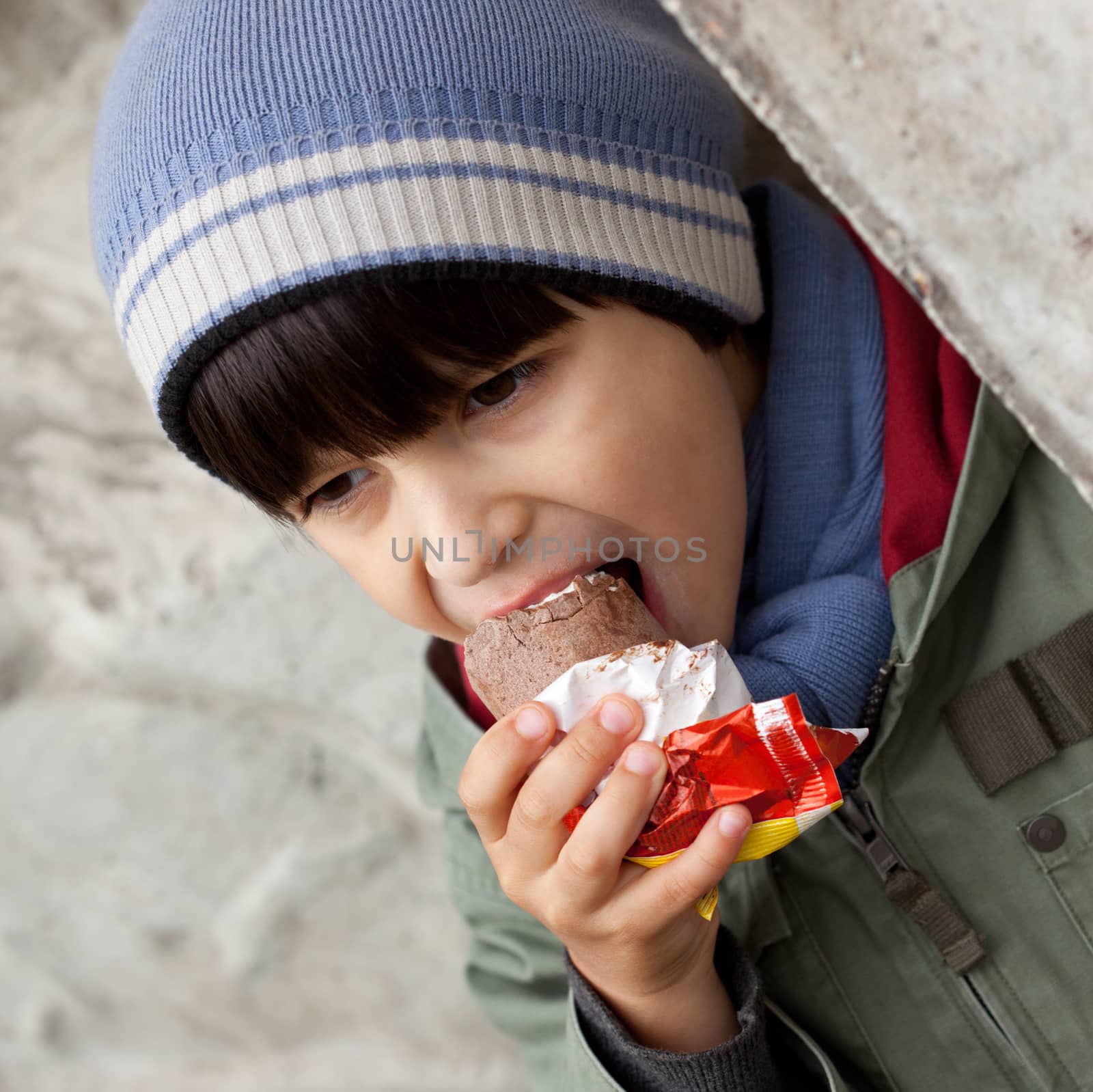 little boy in blue knitted hat  eating ice cream