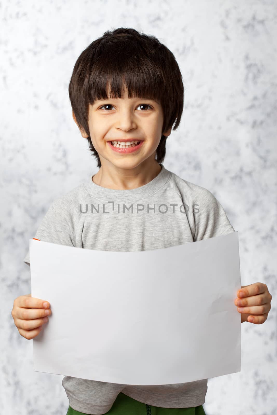 laughing boy  showing  displaying placard ready for your text or product
